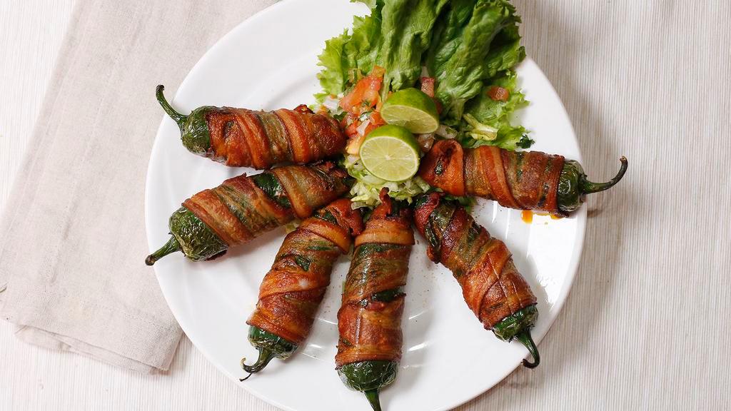 Stuffed Jalapeños · 4  Jalapenos wrapped in bacon stuffed with chorizo and cheese.