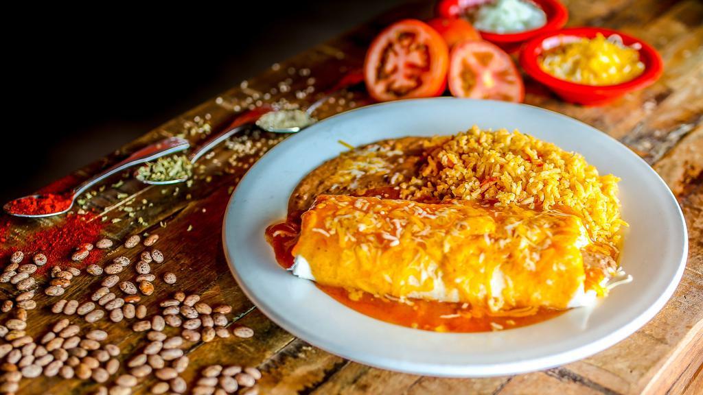 Burrito Al Pastor · Flour tortilla filled with marinated diced pork, Mexican rice, charro beans, pico de gallo, topped with cheese, smothered with green chili and Mexican crema.