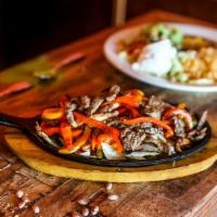 Fajitas (Steak) · Gluten-free. Served on a bed of bell peppers, tomatoes, and onions accompanied by Mexican ri...