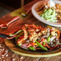 Texas Fajitas Combination · Gluten-free. Tender marinated steak, grilled chicken, and shrimp with sautéed vegetables. Se...