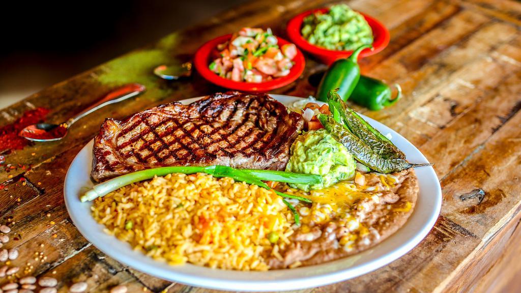 Carne Asada · Gluten-free. Steak marinated in special seasonings and grilled to your liking. Served with Mexican rice, refried beans, pico de gallo and guacamole. Garnished with green onion and fresh roasted jalapeño pepper.

These items may be served raw or undercooked based on your specification, or contain raw or undercooked ingredients. Consuming raw or undercooked meats, poultry, seafood, shellfish or eggs may increase your risk of foodborne illness, especially if you have certain medical conditions. We are not a strictly gluten-free kitchen. While we make every effort to ensure our gluten-free menu meets gluten-free standards, we cannot guarantee this as airborne contaminants may exist.