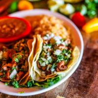 Tacos Al Pastor · Gluten-free. Three soft corn tortillas filled with marinated diced pork, topped with fresh p...