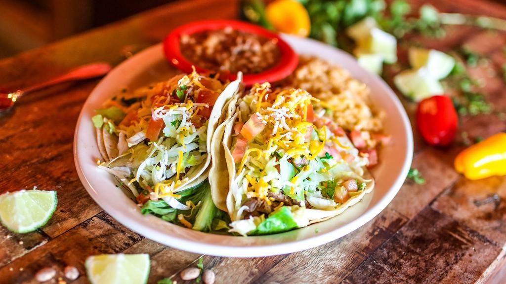 Arandas Steak Tacos · Gluten-free. Three traditional soft
corn tortillas filled with tender steak, pico de gallo, lettuce, and mixed shredded cheese. served with whole beans and Mexican rice.