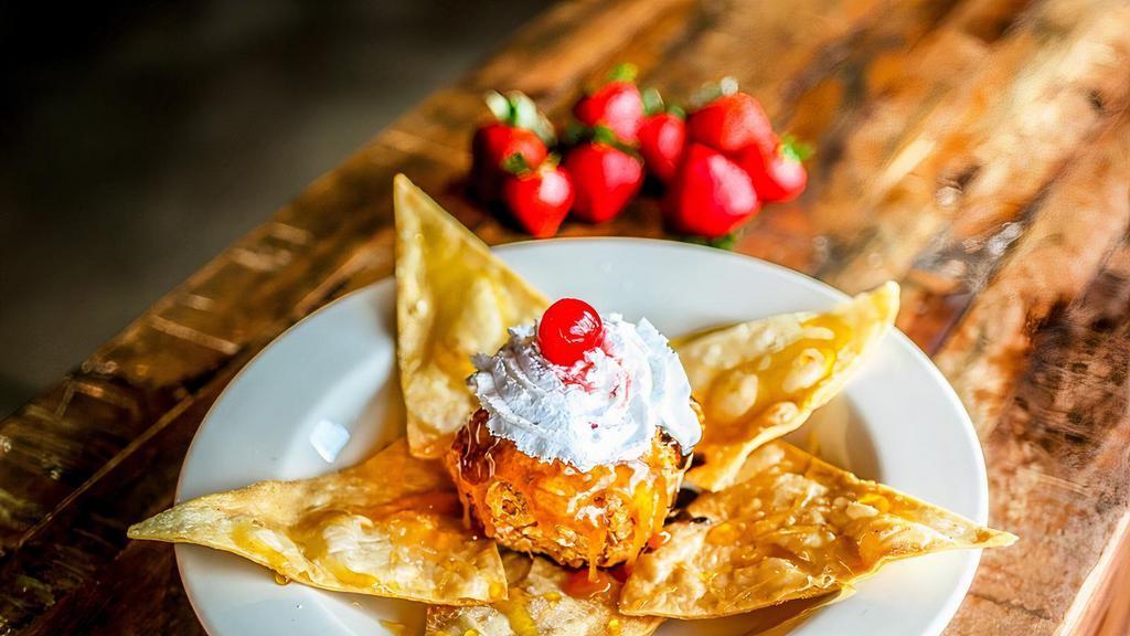 Fried Ice Cream · Vanilla ice cream covered with crispy corn flakes, sweetened with cinnamon and sugar, and then flash-fried. Topped with caramel, chocolate syrup, whipped cream, cinnamon crisps, honey, and a cherry.