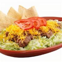 Taco Salad · Fat-free pinto beans, beef or chicken on a bed of shredded lettuce topped with Cheddar chees...