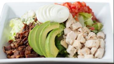 Chef'S Chopped Cobb · Chilled romaine lettuce topped with diced chicken, applewood smoked bacon, bleu cheese crumbles, sliced hard boiled eggs, avocado, and diced roma tomatoes