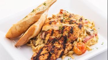 Grilled Cajun Chicken Alfredo · Blackened grilled chicken sautéed in our Cajun alfredo sauce with spaghetti, garlic, cherry tomatoes, mushrooms, roasted red peppers and onions. Served with garlic bread