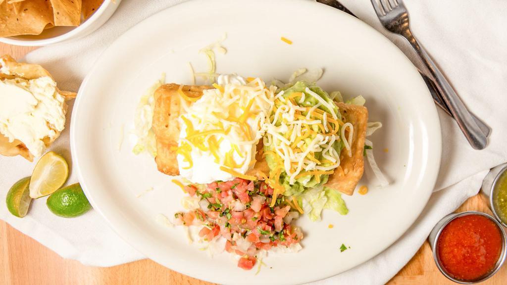 Chimichanga · A large flour tortilla filled with your choice of beans or meat, deep-fried golden brown and topped with guacamole, sour cream, cheese and salsa fresca. Served with a side of rice and beans.