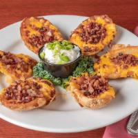 Potato Skins · Six potato skins fried until golden brown, then topped with melted cheddar cheese and bacon....