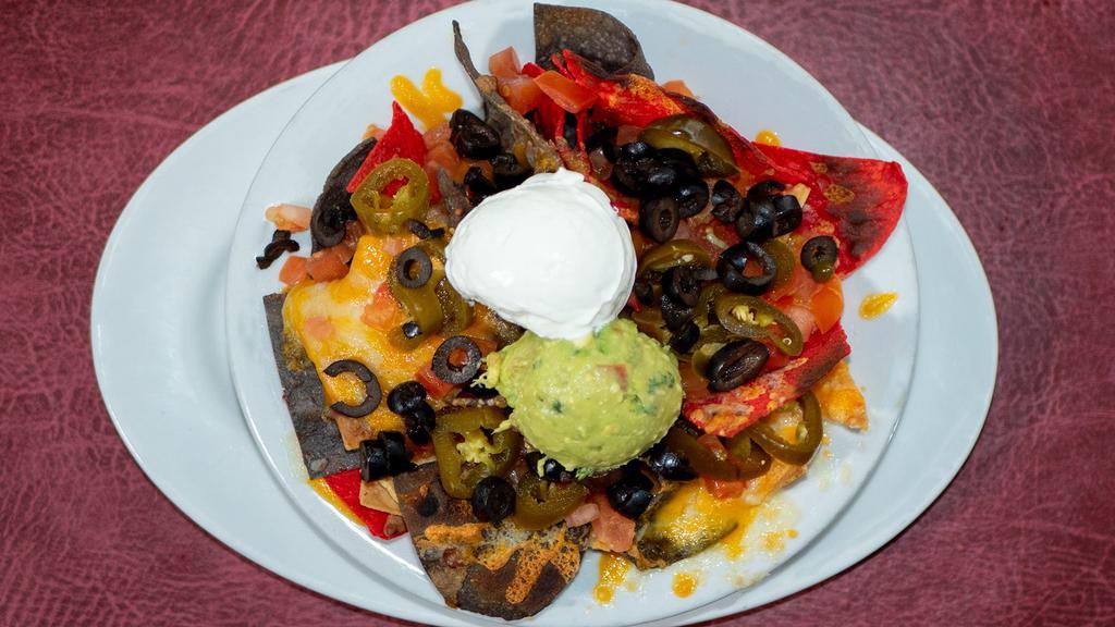Mound O'Nachos · A mound of tortilla chips smothered with refried beans, cheddar and jack cheese, tomatoes, black olives, jalapenos, sour cream, & guacamole.
