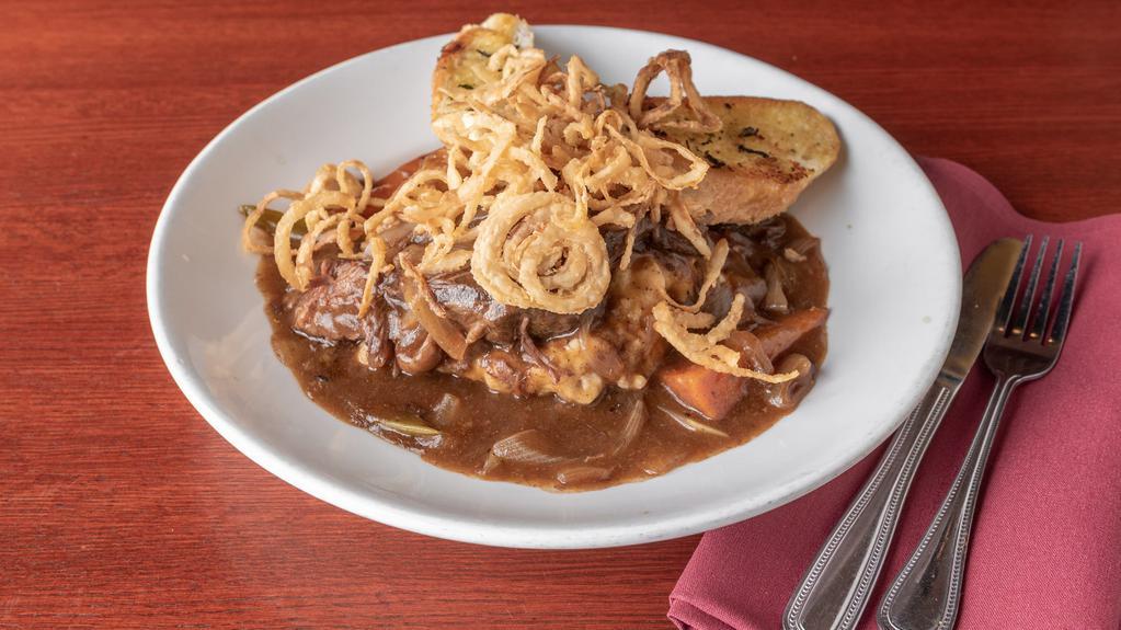 Crockpot Pot Roast · Tender pieces of pot roast simmered in hearty brown sauce with onions, celery, and carrots served over garlic mashed potatoes with garlic crostini and crispy onion straws.
