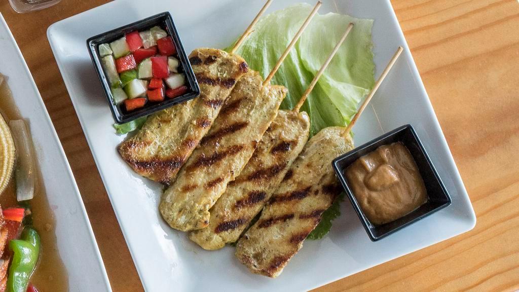 Yum Satay Gai - Chicken Satay Salad · Grilled chicken mixed with red onions and topped with cilantro, served on a bed of lettuce with cucumber salad and peanut sauce.