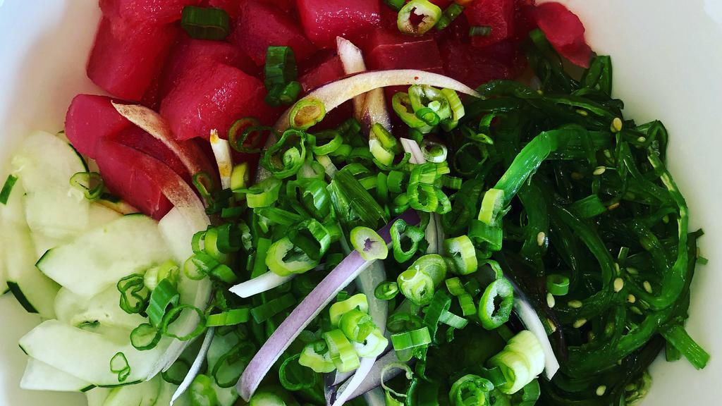 Classic Tuna Poke Bowl · Ahi tuna, avocado, cucumber, seaweed salad, red onion, green onion, mango, and house sauce.
