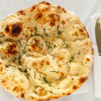 Garlic Naan · A soft white flour bread baked in the tandoor filled with onions and garlic.