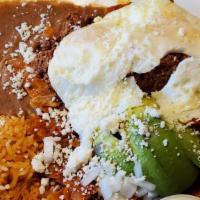 Chilaquiles · Corn tortillas simmered in a spicy tomato salsa topped with diced onion, queso fresco, slice...
