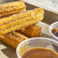 Churros · Fried-dough pastry with cinnamon and sugar. Served with hot chocolate and caramel.