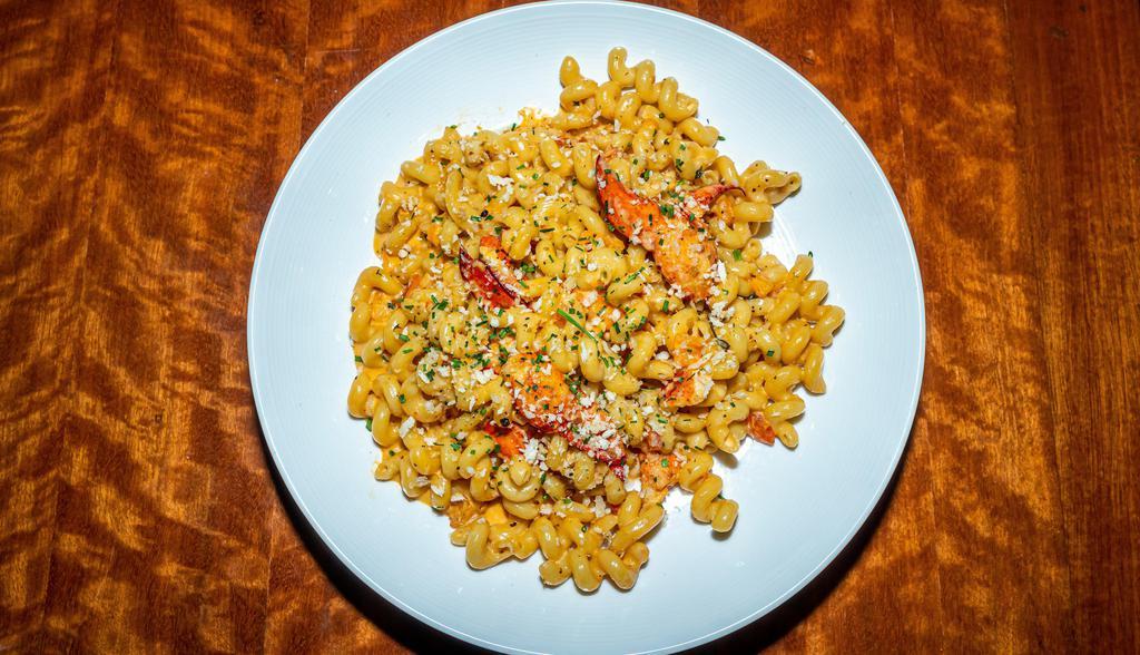 Lobster Mac & Cheese · lobster meat sautéed with fresh garlic & white wine, then tossed with cavatappi noodles in a swiss cheese & lobster cream sauce, all topped with toasted seasoned breadcrumbs & finished with truffle oil.