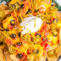 Classic · Tortilla chips topped with cheddar cheese, cheese sauce, sour cream, black olives, tomatoes ...