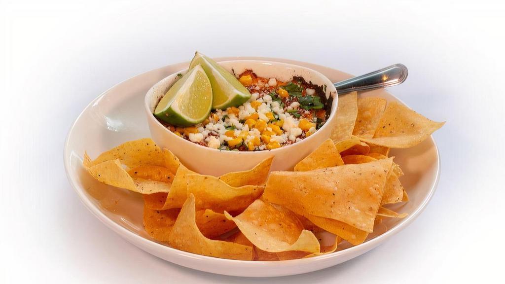 Elote Queso · Elote-style queso dip with roasted corn, cotija, cilantro, queso fresco and lime. Served with fresh tortilla chips.       .       .       .            .       .       .       .