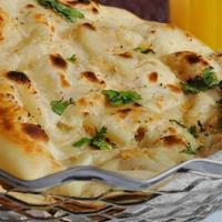 Tandoori Butter Naan · Clay oven baked fluffy white bread lightly brushed with butter.