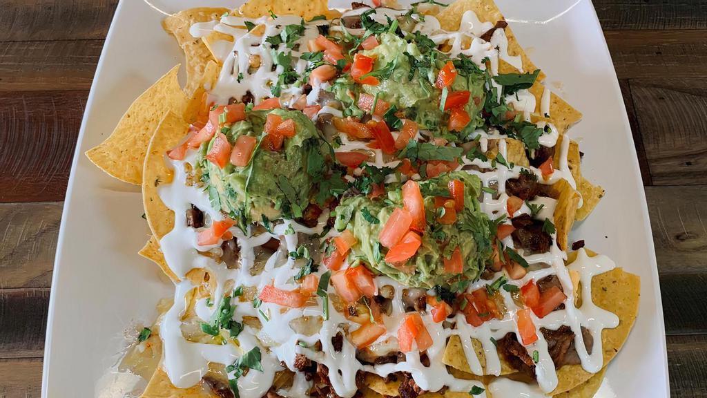 Nachos W/ Meat · Tortilla chip Beans chihuahua cheese sour cream and guacamole and your choice of meat.