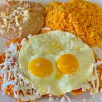 Chilaquiles Red · 2 eggs your way, crispy corn tortilla simmered with salsa, epazote and red onions topped wit...