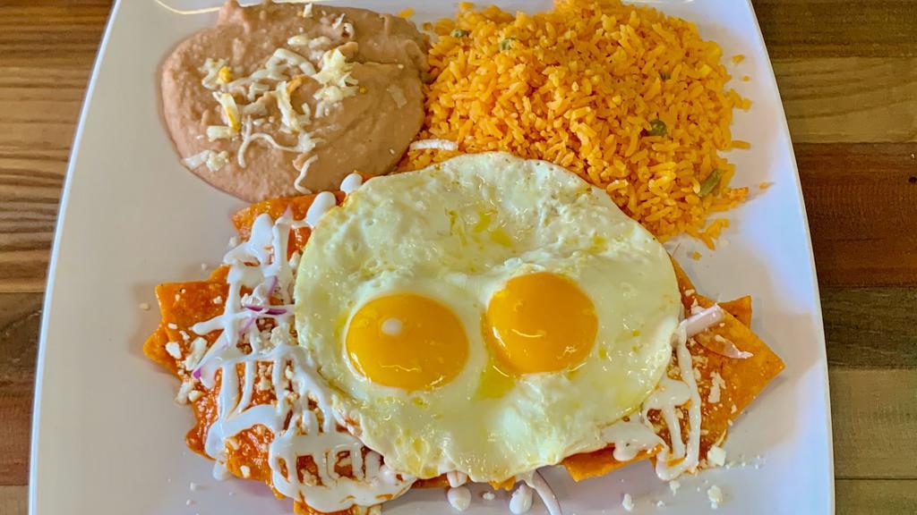Chilaquiles Red · 2 eggs your way, crispy corn tortilla simmered with salsa, epazote and red onions topped with fresh cheese sour cream served with mex rice and beans.