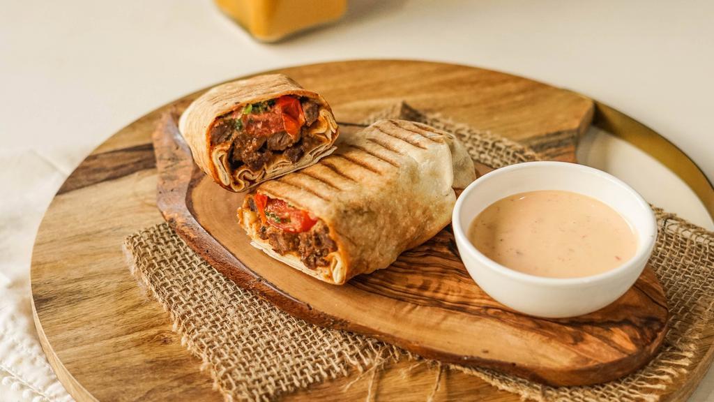 Banging Beef · Sliced beef with a tomato-onion relish, layers of hummus, red pepper, garlic and parsley, encased in pita