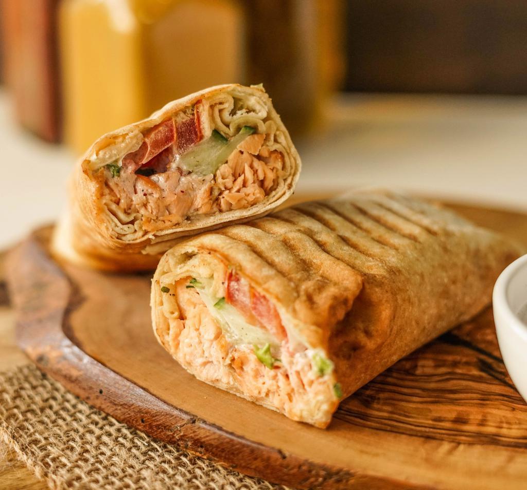 Swimming Shawarma · Marinated salmon with herbs and spices grilled to perfection served in a pita with lettuce, cucumber, tomato and tzatziki