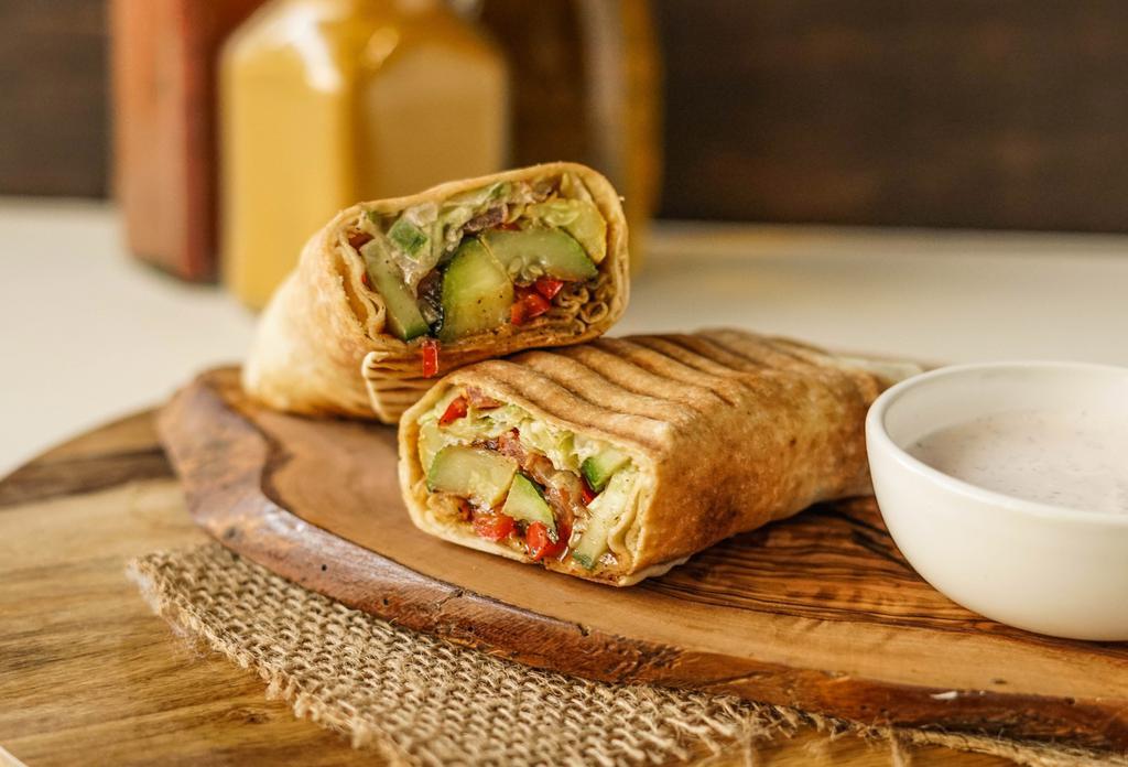 Veggie Delight · Grilled zucchini, squash, cauliﬂower, tomatoes, onions and red peppers seasoned with sumac and pomegranate molasses, layered with hummus and pita