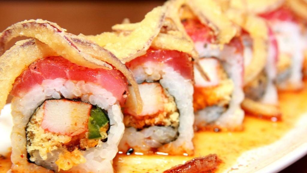 Cafe Icon Signature Roll · Crab stick, jalapeno, tempura crispy, and masago roll topped with your choice of peppered tuna or sesame salmon, drizzled with our signature spicy icon sauce and topped with fried onions.