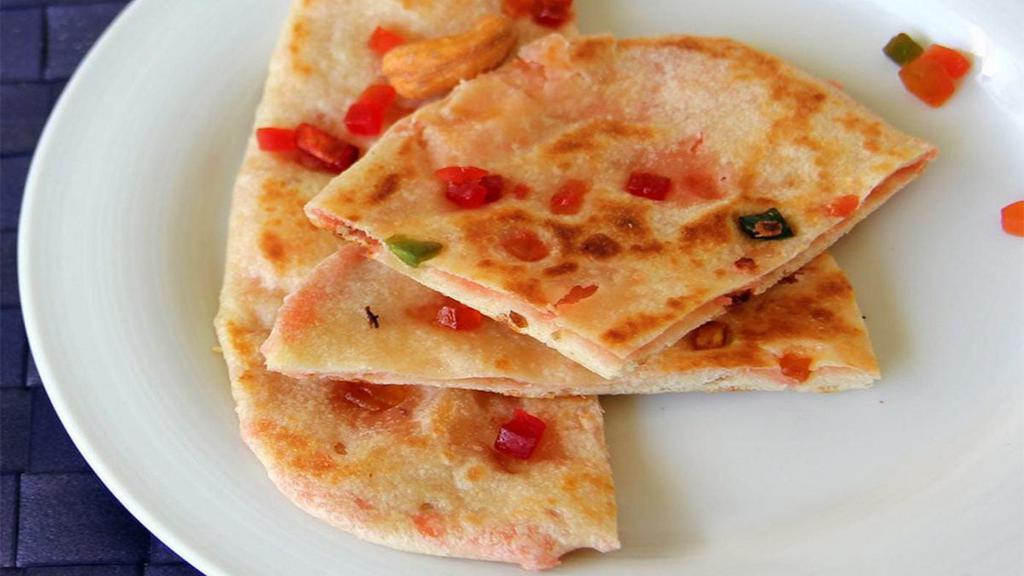 Kashmiri Naan · Flat Bread Stuffed With Variety Of Grounded Dry Nuts & Raisins.