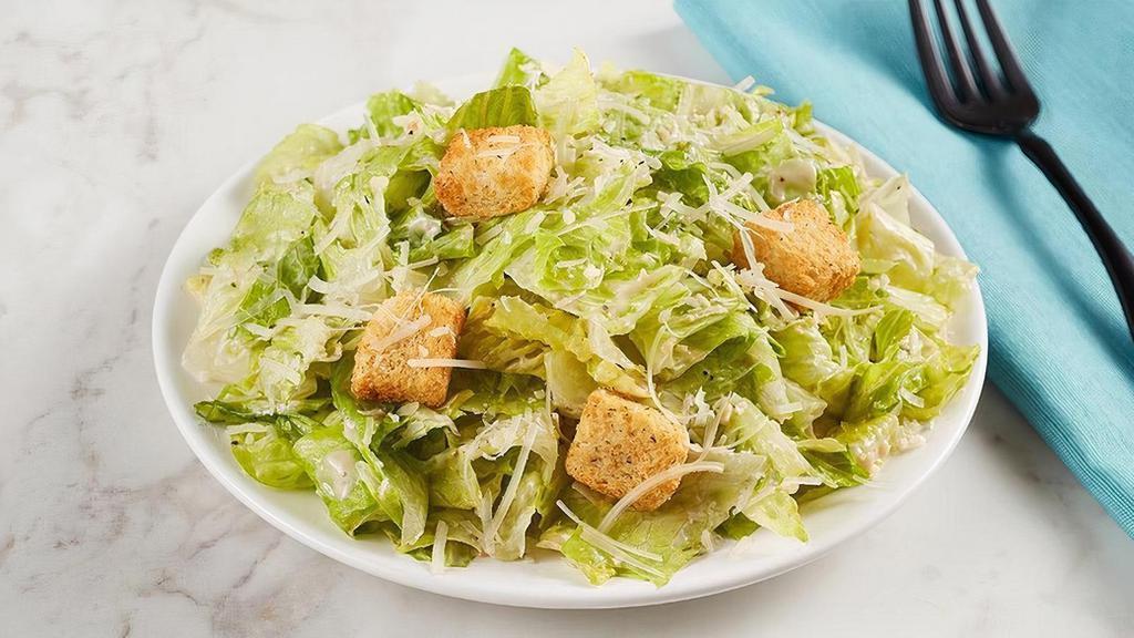 Side Caesar Salad · Crisp romaine lettuce tossed with parmesan cheese and croutons and a side of Caesar dressing.