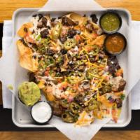 Smokehouse Nachos · Crisp tortilla chips layered with melted cheese and piled high with smoked brisket, black be...