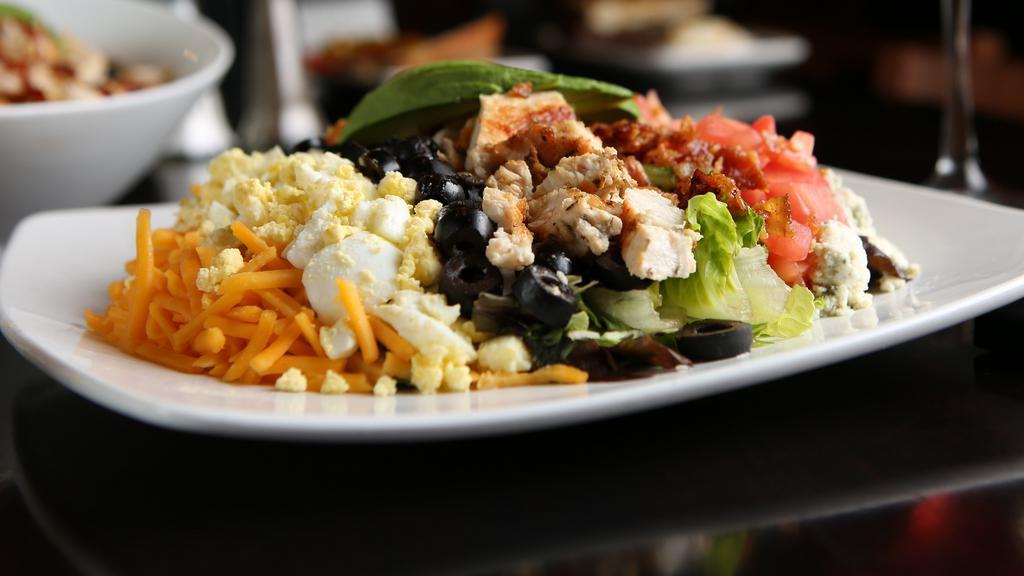 Chicken Cobb Salad · Chopped garden blend, chicken, applewood smoked bacon, tomatoes, black olives, cheddar and gorgonzola cheeses, hardboiled egg and avocado. Choice of dressing.