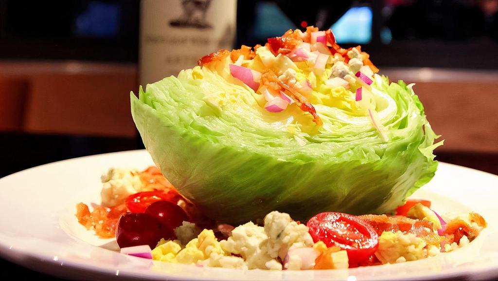 Wedge Salad · Wedge of iceberg lettuce, bacon, diced egg, red onion, crumbled gorgonzola, cherry tomatoes and bleu cheese dressing.