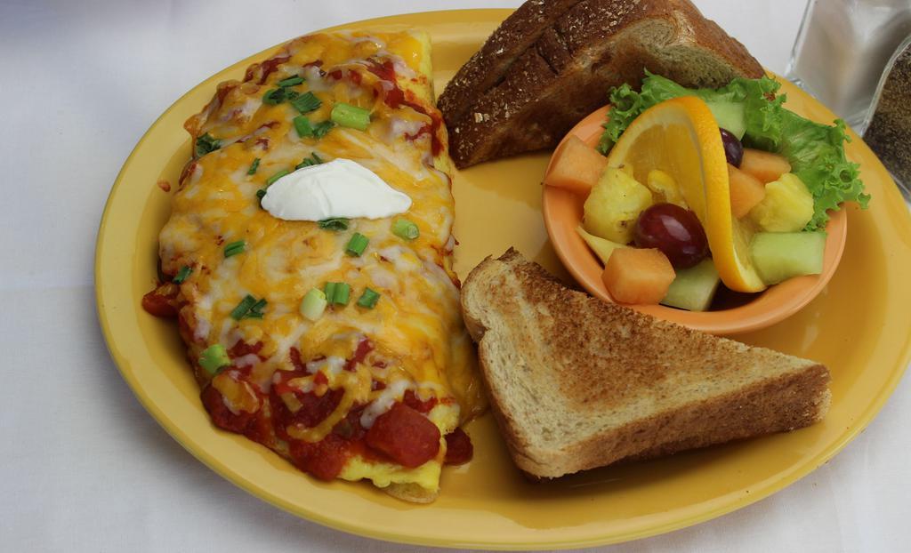 South Of The Border Omelette · Stuffed with chorizo sausage, green chilies, onions, homemade salsa, a blend of monterey jack and cheddar cheeses and topped with sour cream, and chives. Add-ons for an additional charge. Comes with your choice of sides.