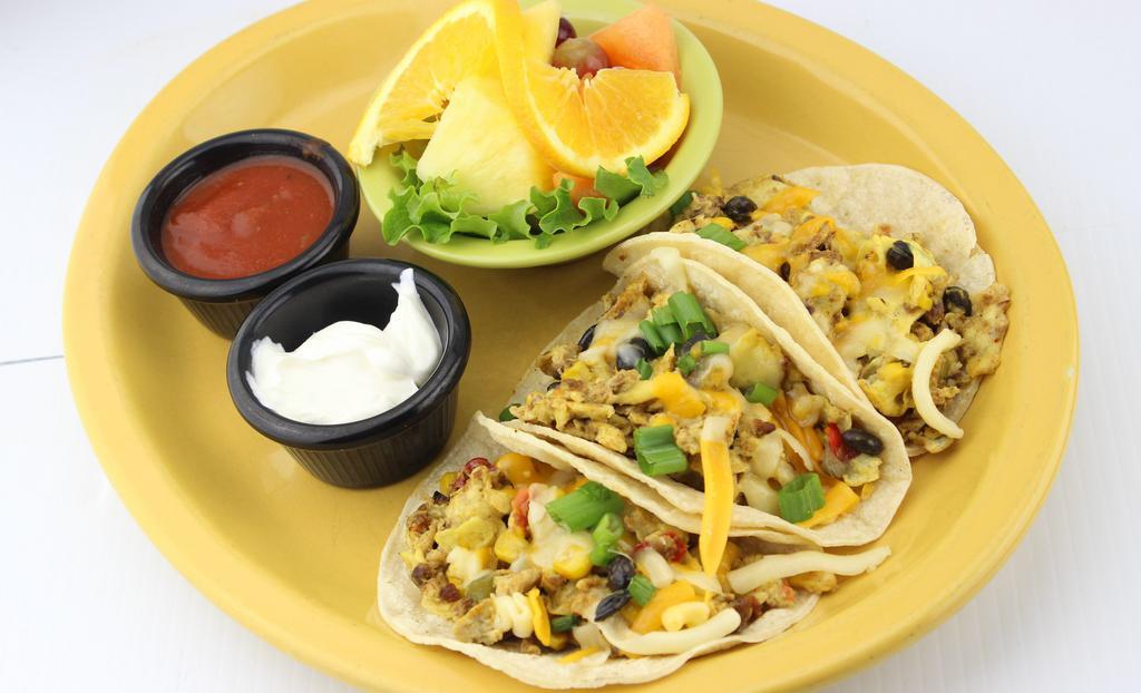 Breakfast Tacos · Three corn tortillas filled with our fresh cracked eggs, scrambled with chorizo sausage, black bean and corn salsa, cheeses tomatoes, and green onion with homemade salsa and sour cream.