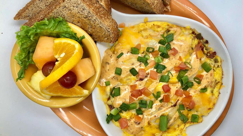 Southwest Frittata · Cheddar and Monterey Jack cheese, chicken, diced bacon, onions, tomatoes, and jalapenos blended into a fluffy egg frittata and drizzled with chipotle ranch sauce.