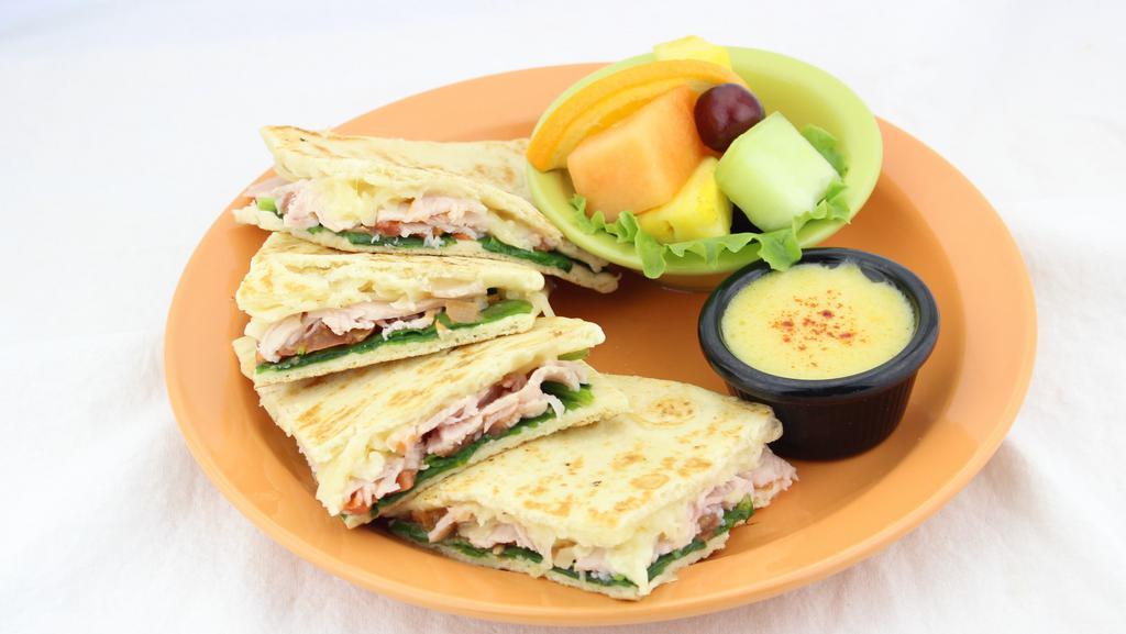 Turkey Flatbread · Natural honey smoked turkey, spinach, tomatoes, and swiss cheese pressed into a one-of-a-kind sandwich. Served with creamy Hollandaise.