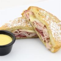 Monte Cristo · Our signature sourdough French toast filled with lean ham and turkey topped with fresh swiss...