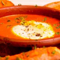 Queso De Cabra Al Horno · Herbed goat cheese baked in tomato basil sauce, toasted baguettes with tomato, garlic and ol...