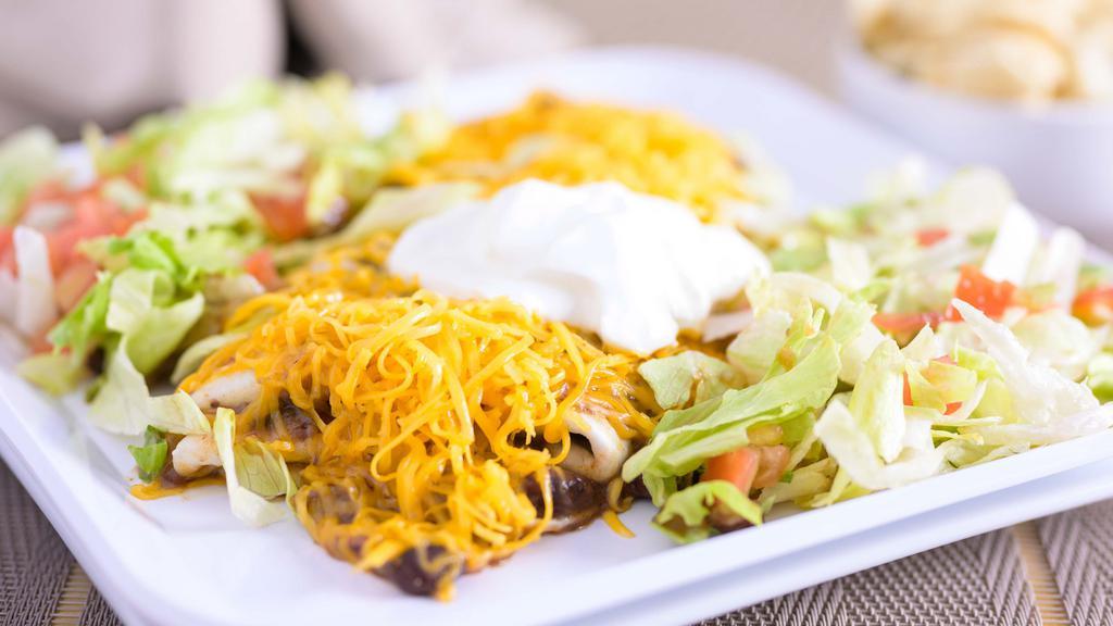 Vegetarian Black Bean Deluxe Burrito · Skyline black beans and rice in a tortilla, topped with more black beans and rice, tomatoes, lettuce, shredded cheddar cheese and sour cream.