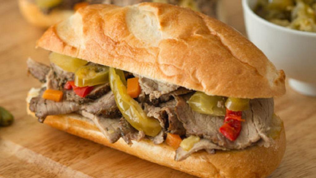 Italian Beef Sandwich · Tender, thin-sliced roasted round of beef seasoned with Italian spices, dipped in warm au jus and topped with flame-roasted peppers and onions. Served on a Turano roll with additional au jus and mild giardiniera on the side.