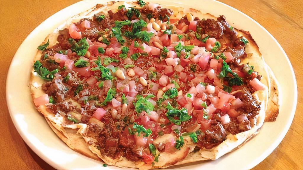 Arayiss Pitza · Contains Nuts. Our award-winning Hummus topped with seasoned lean ground beef, diced tomatoes, lightly fried pine nuts, and chopped parsley