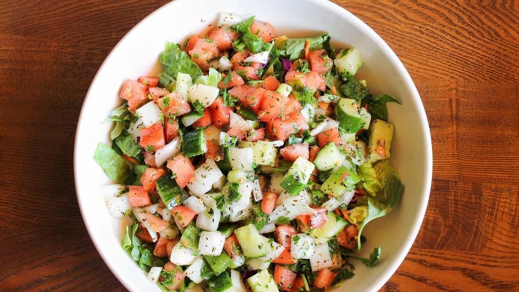 Lebanese Salata · Vegan, Gluten-Free. Chopped tomatoes, cucumbers, green peppers, scallions, onions, and parsley tossed with extra virgin olive oil and lemon juice on a bed of mixed greens