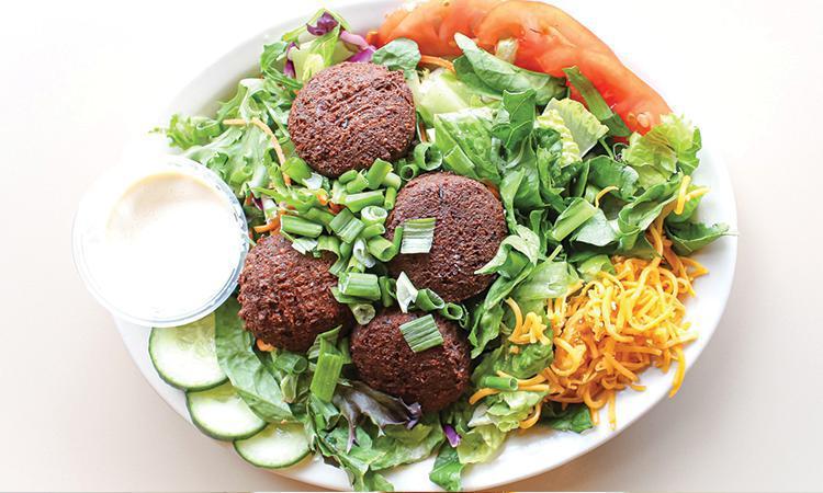 Falafel Salad · Vegetarian, Gluten-Free, Contains Nuts. Falafel patties over mixed greens, sliced cucumbers, tomatoes, and scallions served with Tahini Lemon dressing; choice of cheddar or feta