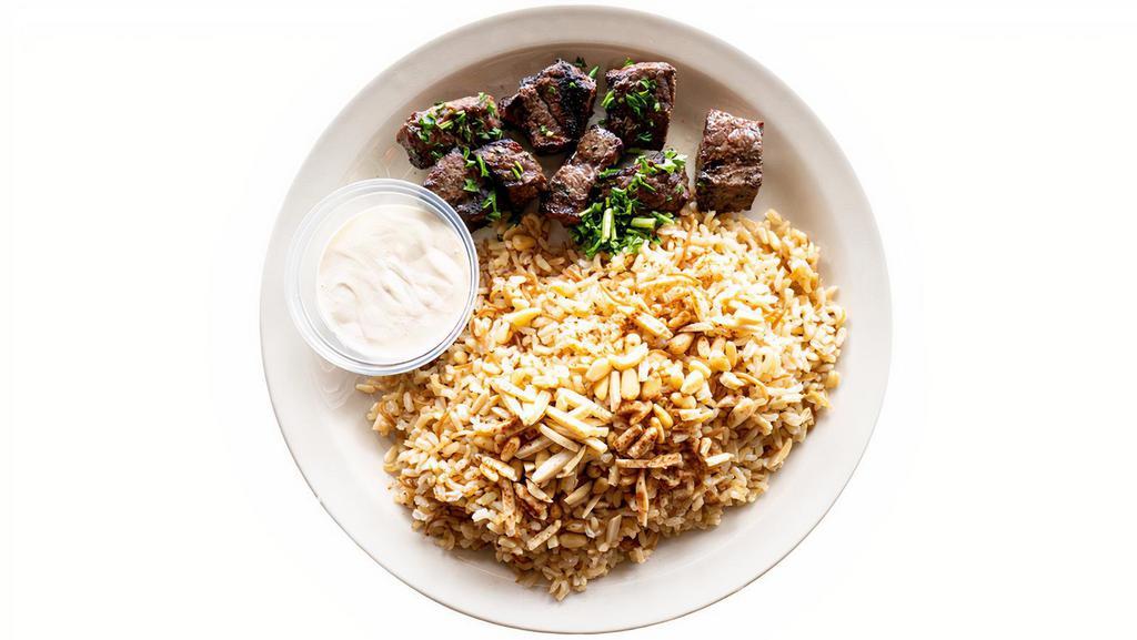 Mediterranean Shish Kabob Plate · Contains Nuts. Grilled beef tenders served with brown rice with vermicelli, lightly fried pine nuts and almonds, and a hint of cinnamon; choice of Garlic Sauce or Tahini Lemon dressing