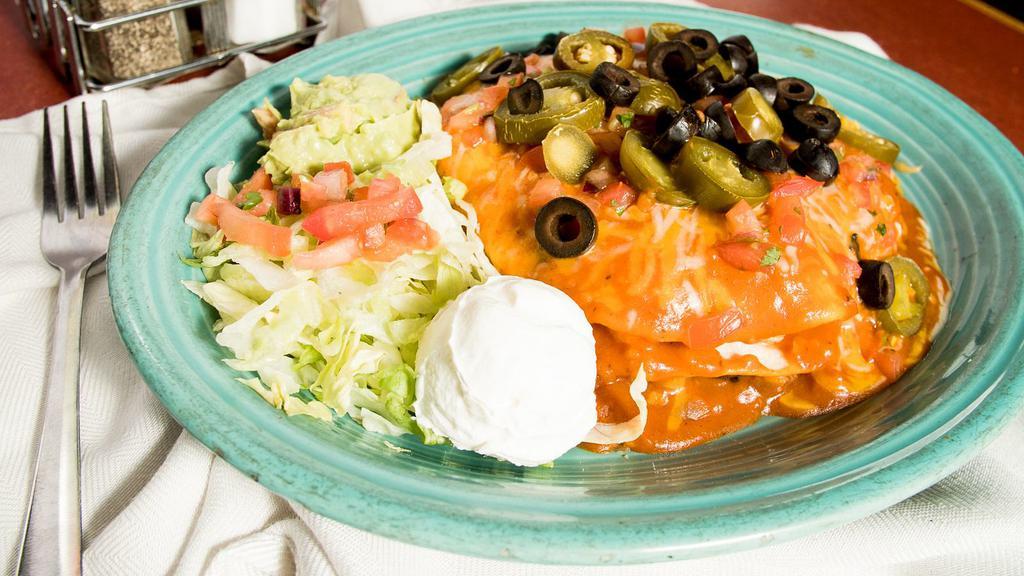 Enchilada Estancia · Soft corn tortillas layered with chicken and pinto beans then topped with your choice of signature sauce, jalapeños, black olives, pico de gallo and shredded cheese. Served with a side of sour cream and guacamole.