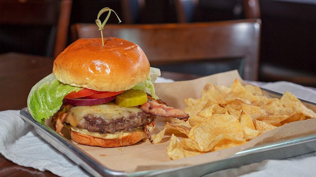 All-American Burger · Aged cheddar, applewood bacon, lettuce, tomato, pickle on a butter brioche bun.
